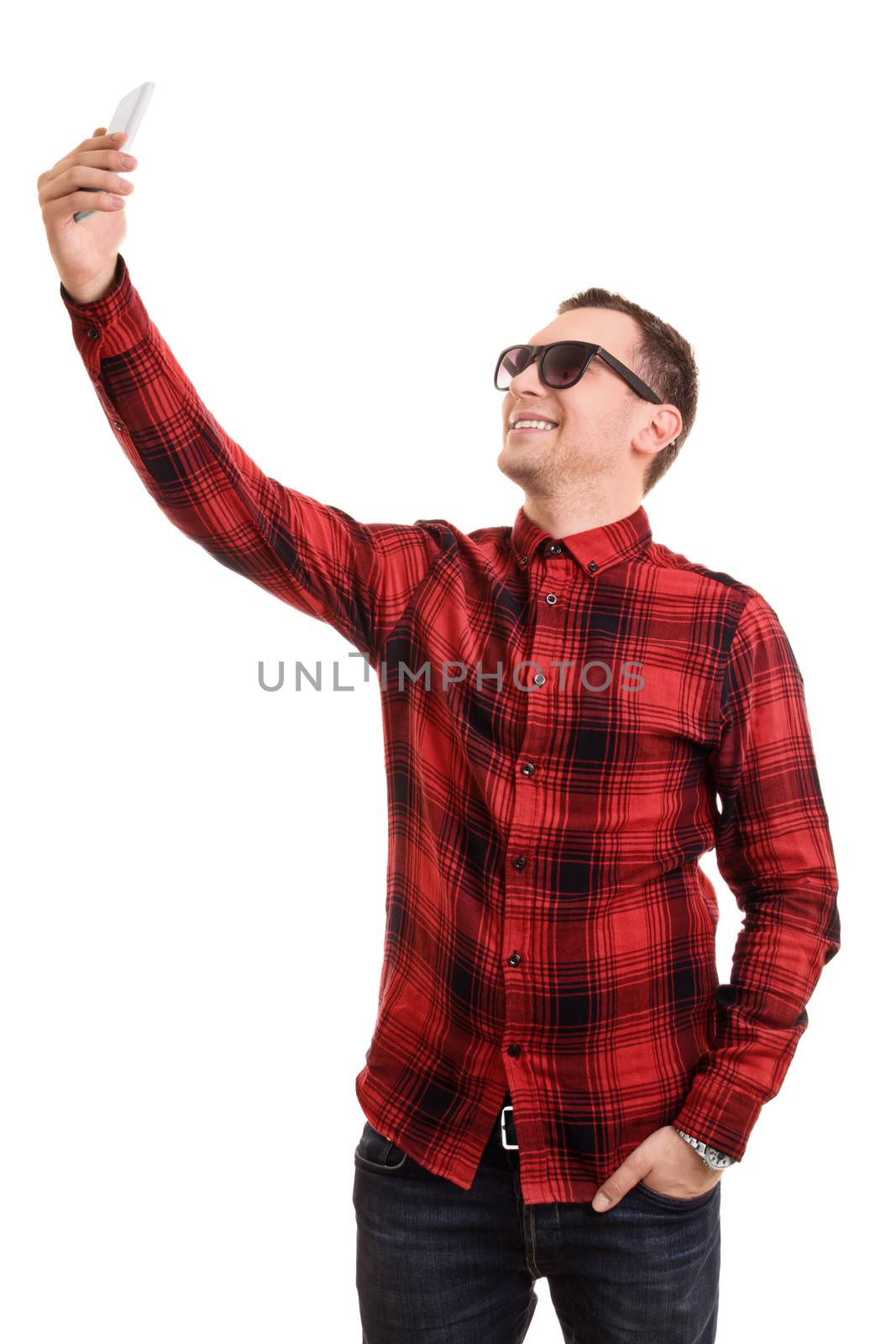 A portrait of a fashionable young man taking a selfie, isolated on white background.