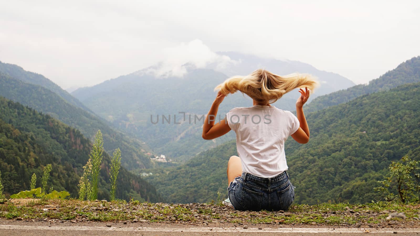 Cheering woman hiker open arms at mountain peak by natali_brill