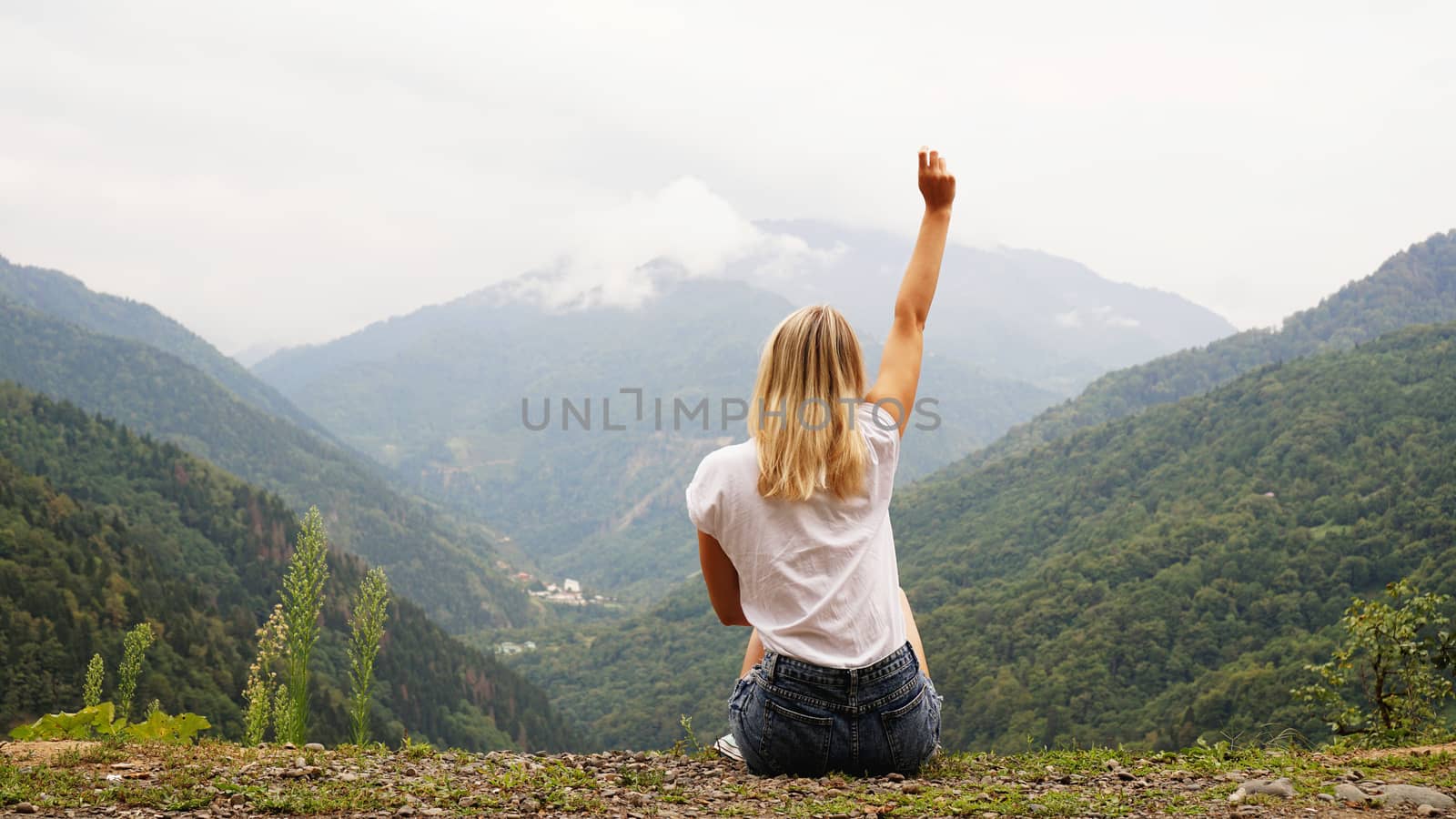 Cheering woman hiker open arms at mountain peak by natali_brill