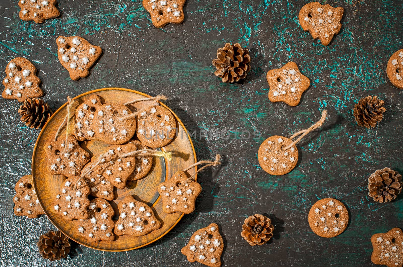 Christmas theme with cookies, spruce cones on a dark background. Flat lay