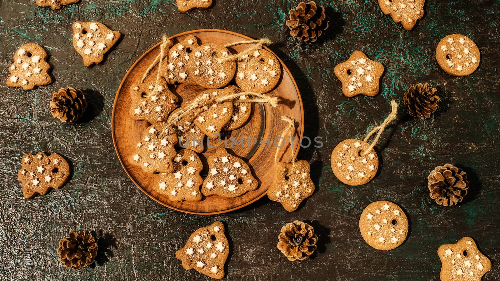 Christmas theme with cookies, spruce cones on a dark background. Flat lay