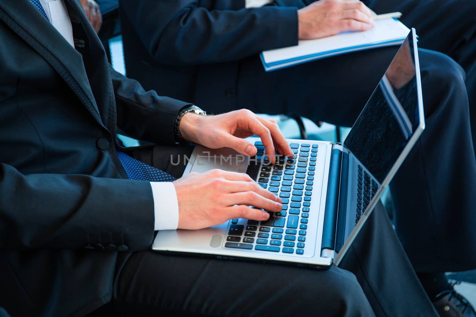 Business man with laptop at conference by ALotOfPeople