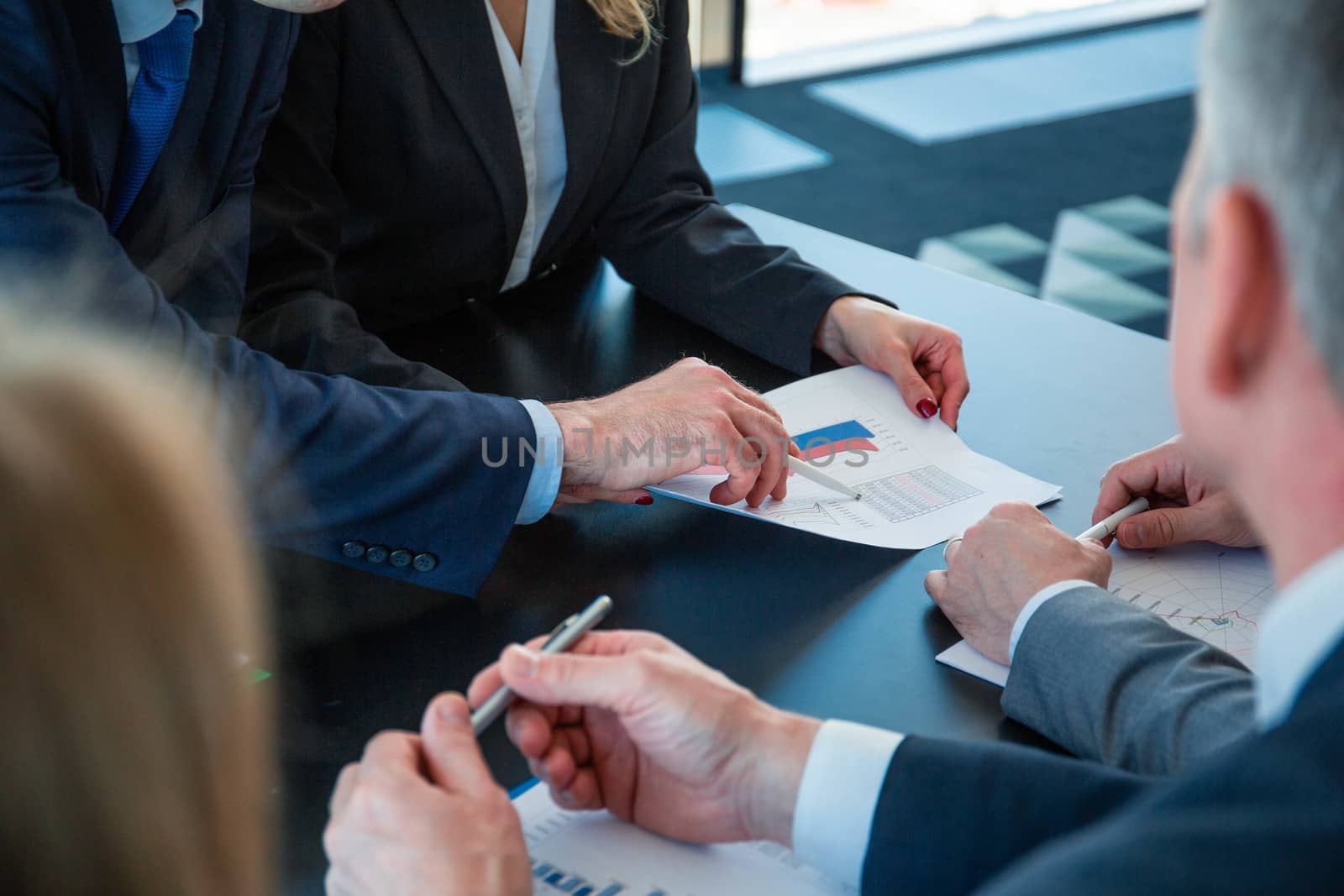 Serious business people work with graphs and diagrams at meeting at office table