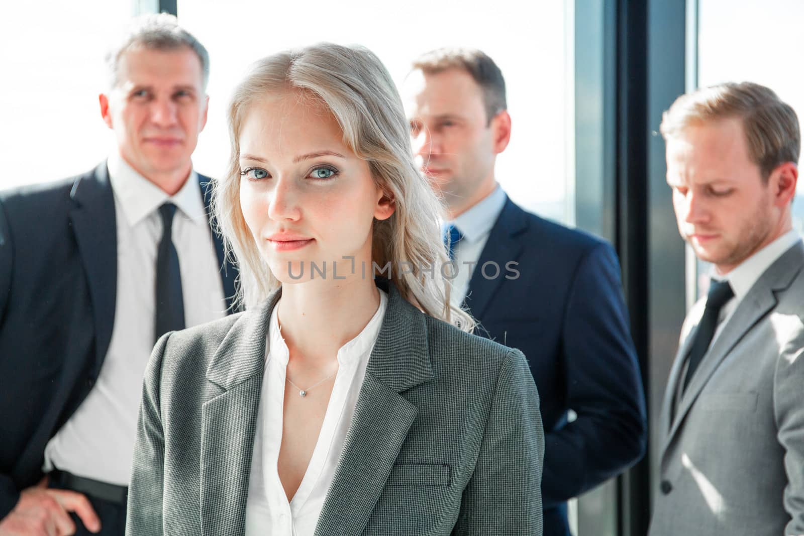 Portrait of young business woman and her team in office
