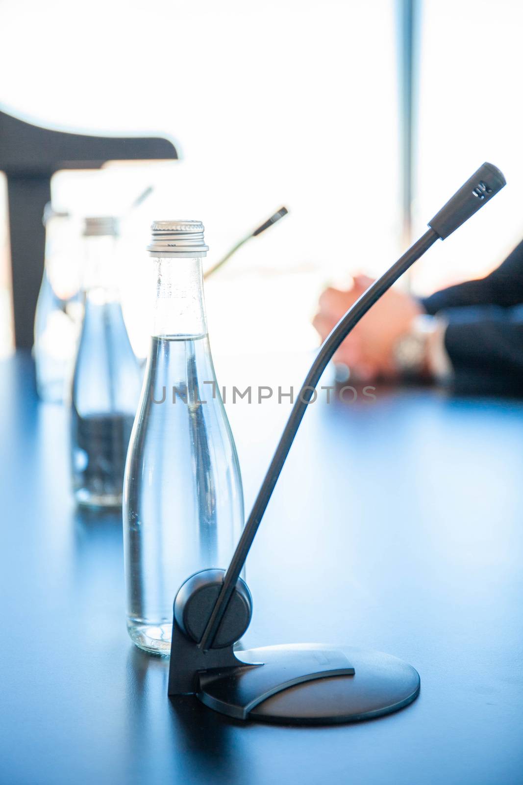 Conference room table for business meeting with microphones and bottles of water