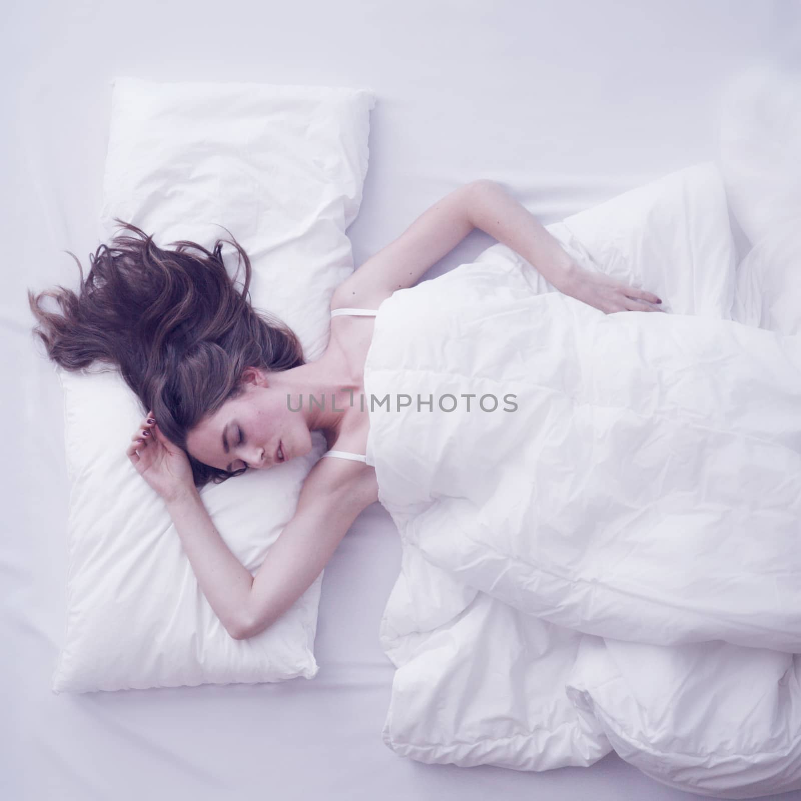 Young woman sleeping in bed by ALotOfPeople