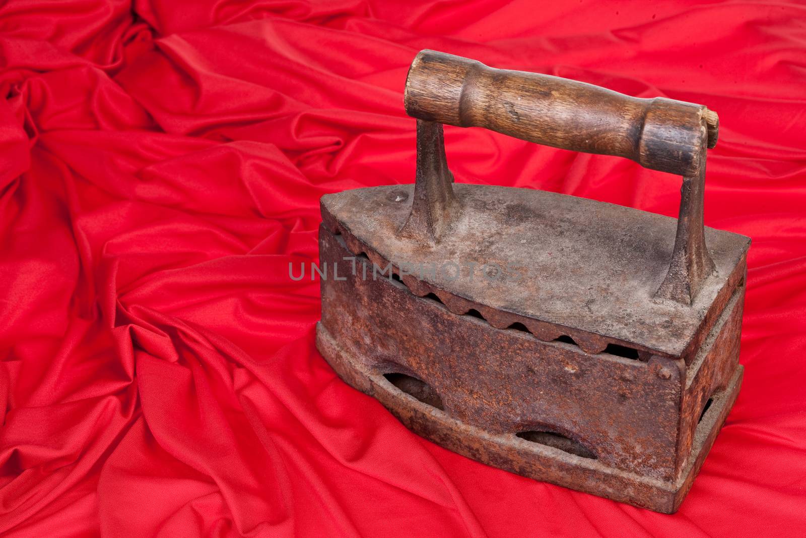 Old rusty iron and a piece or red textile on isolated background
