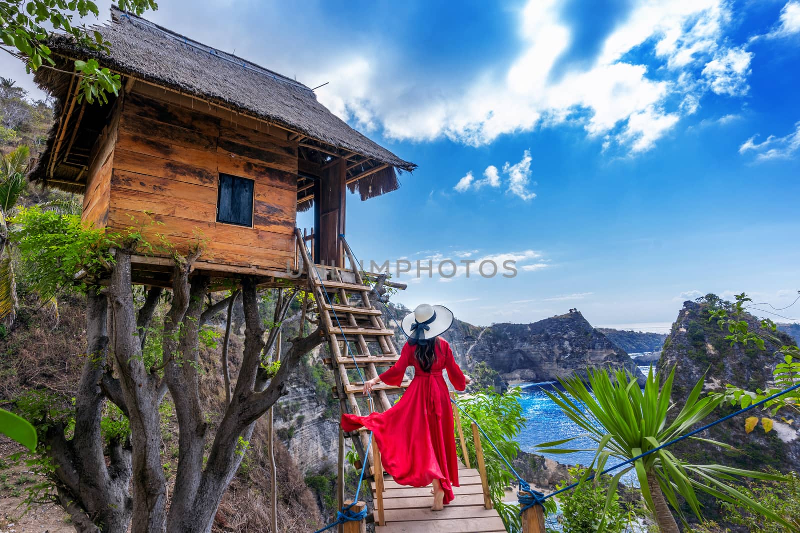 Young girl on steps of house on tree at Atuh beach in Nusa Penida island, Bali in Indonesia.