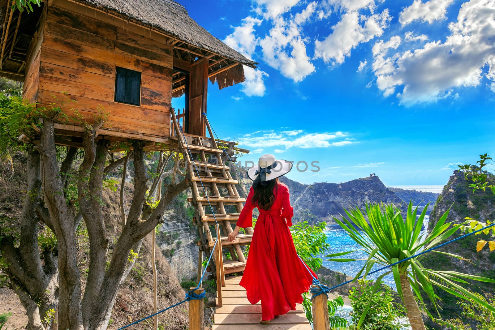 Young girl on steps of house on tree at Atuh beach in Nusa Penida island, Bali in Indonesia.