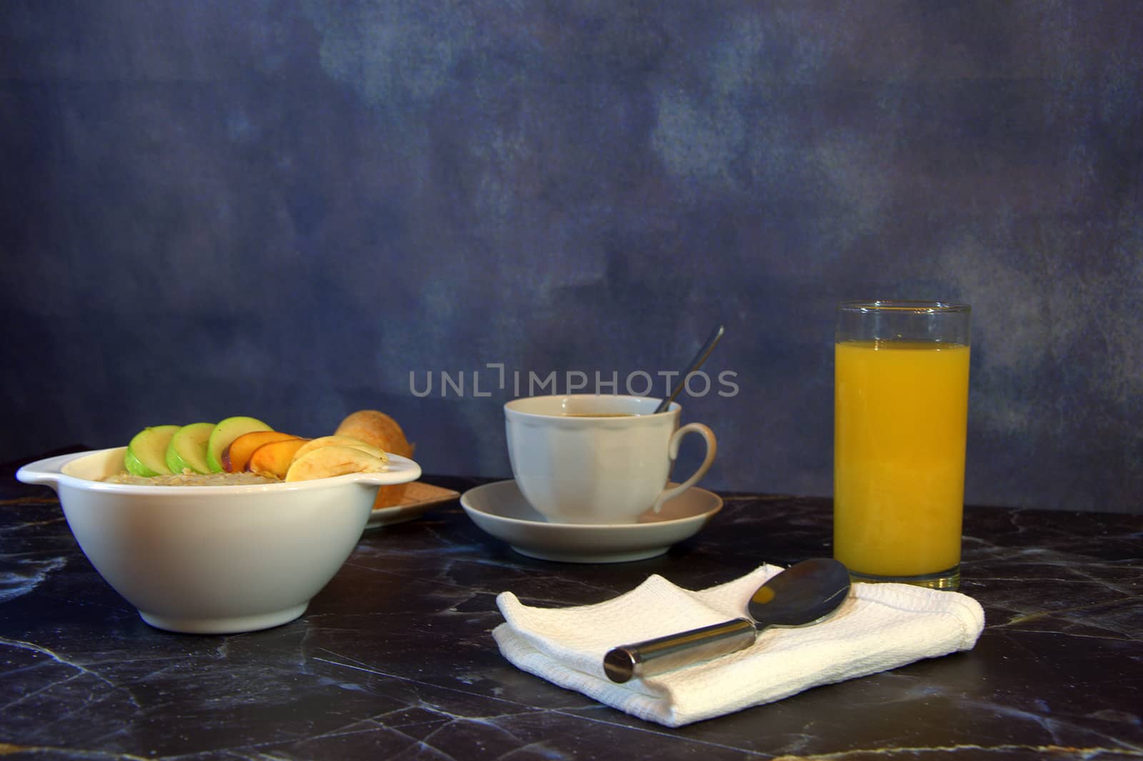 Proper breakfast, a plate of oatmeal with fruit slices, a glass of orange juice, a cup of coffee and two croissants.