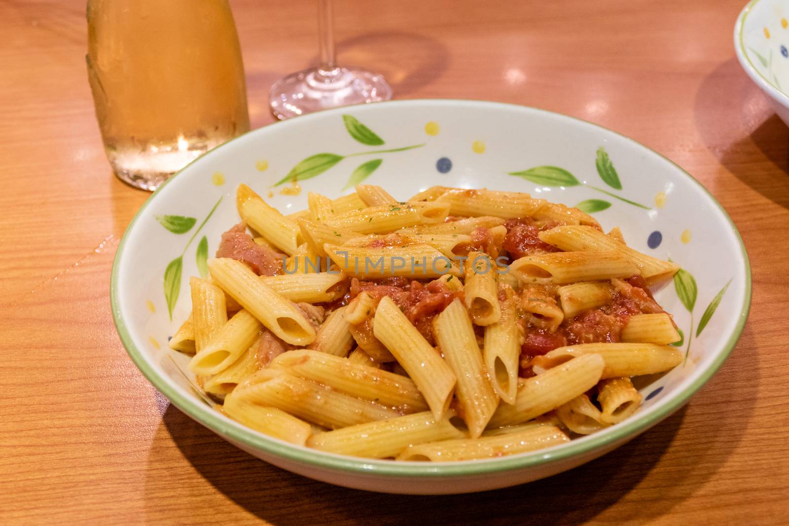 Pasta alfredo penne with tomato based sauce in plate