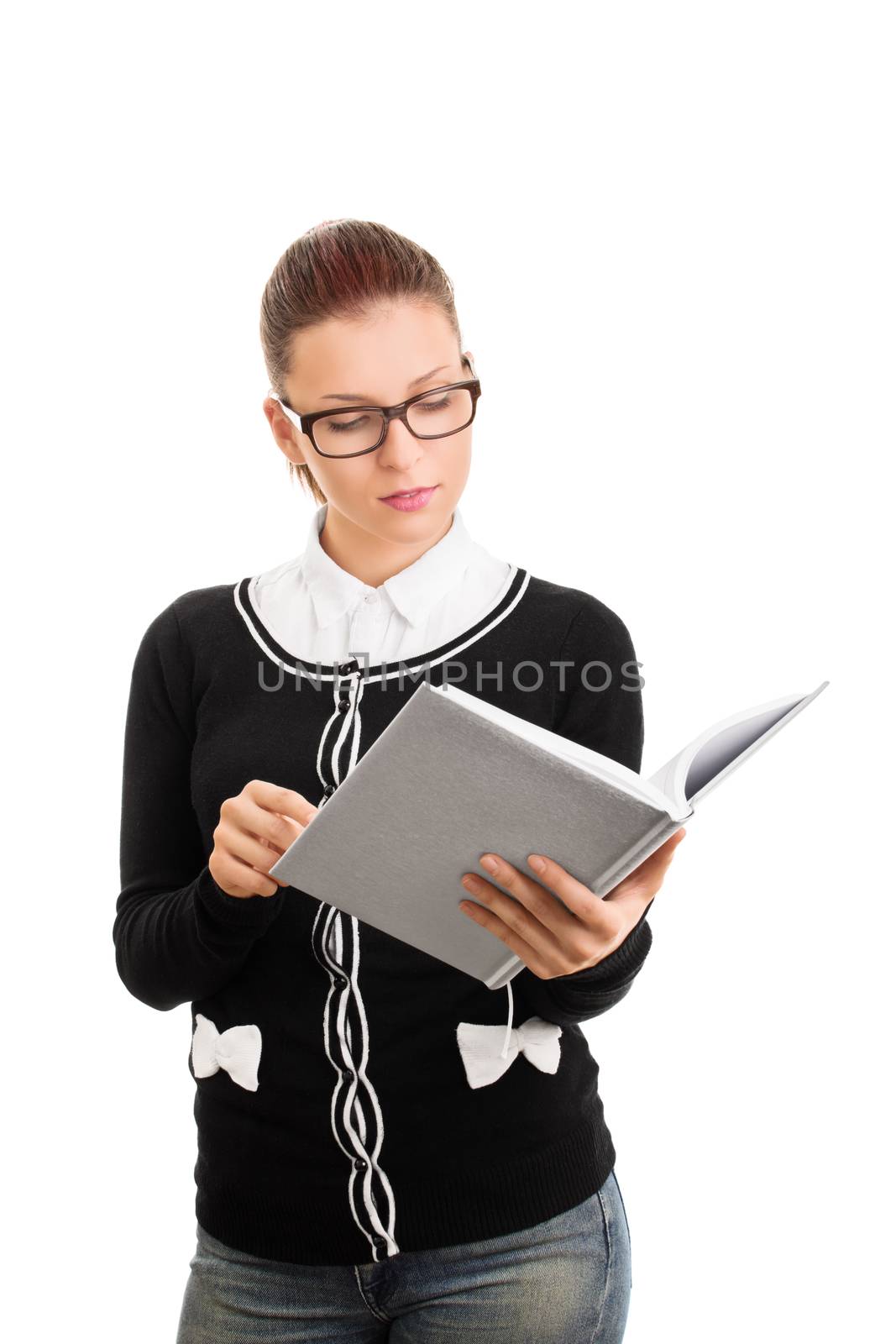 Hmm, I really need to go through these notes again. Beautiful young student girl with glasses looking at an open notebook, isolated on white background.