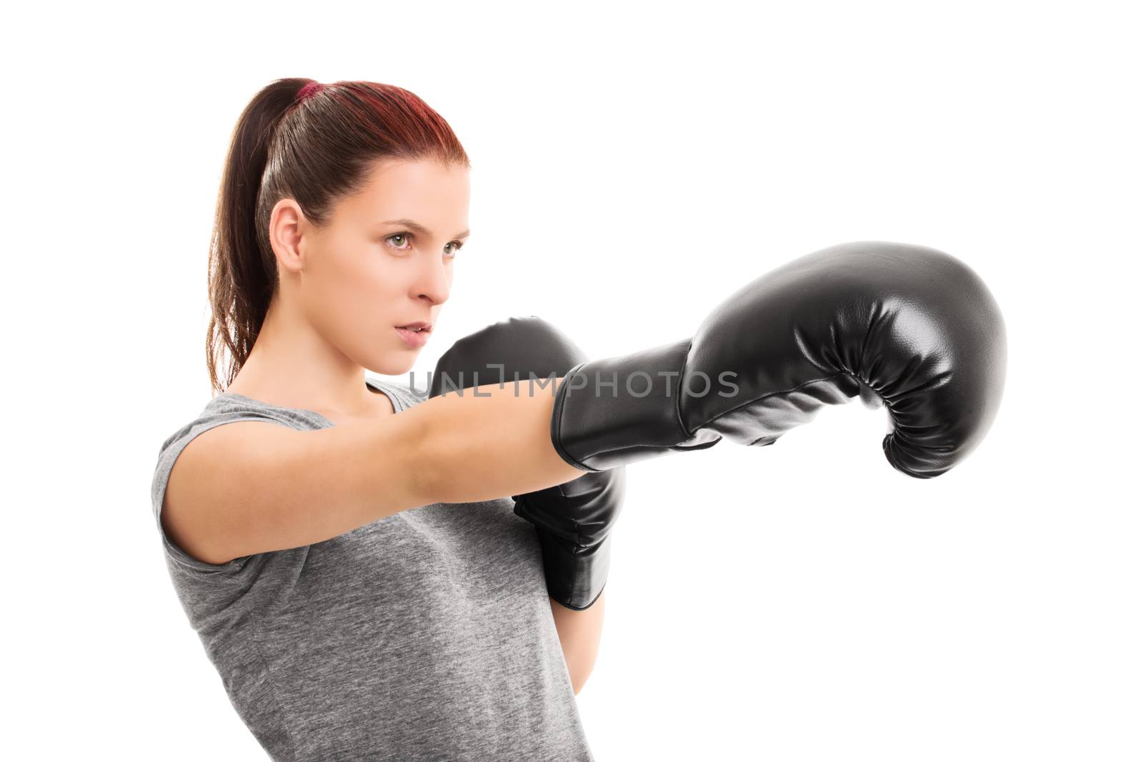 Close up shot of a beautiful young female boxer with boxing gloves punching, isolated on white background.