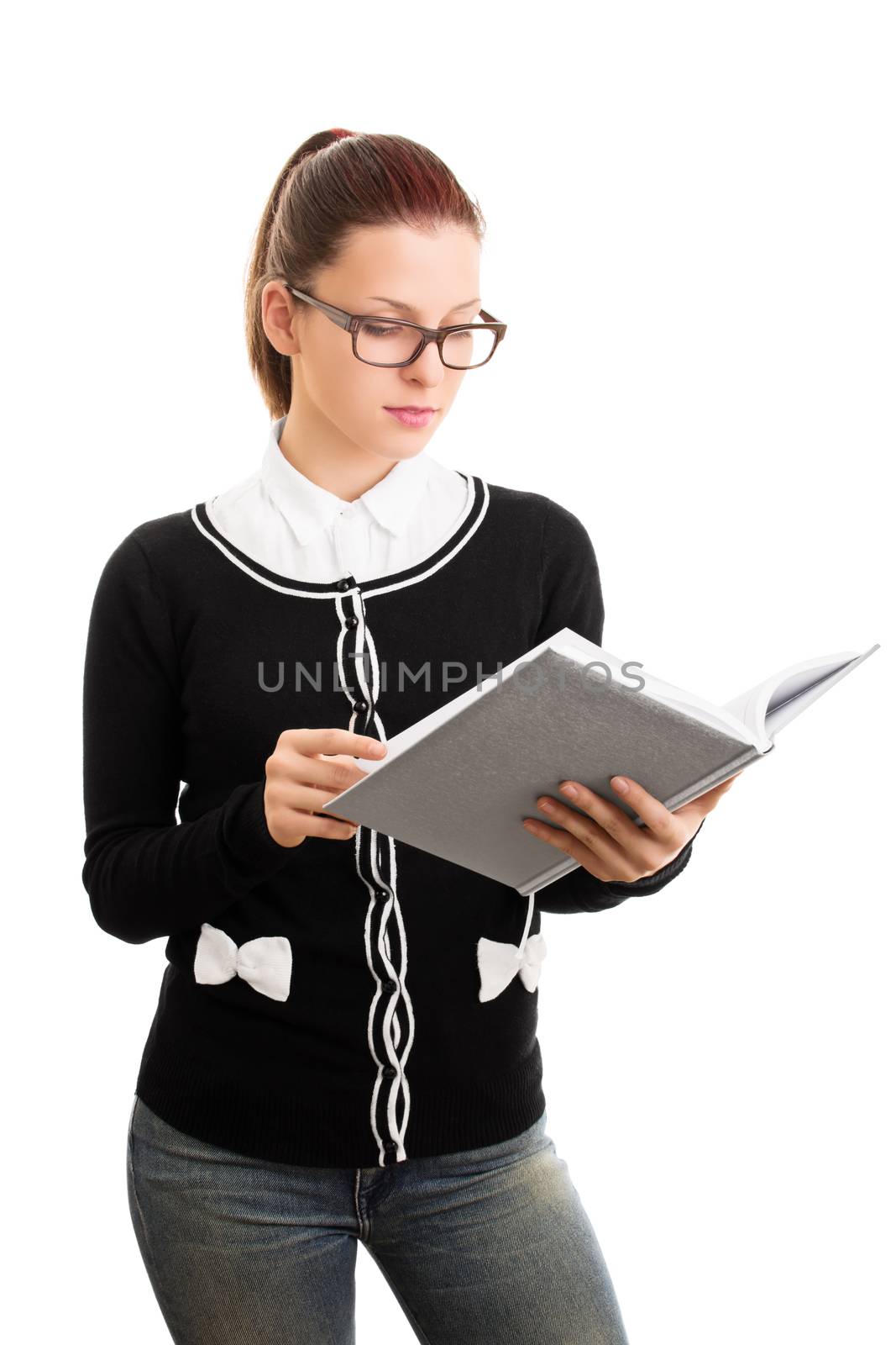 Reviewing notes. Reading something. Beautiful young student girl with glasses looking at an open notebook, isolated on white background.