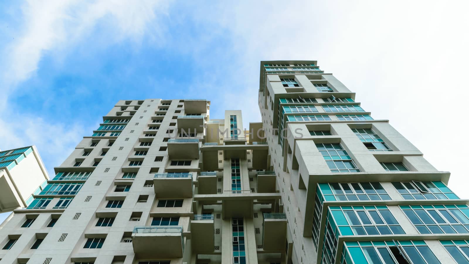 Low angle view of Modern skyscrapers Buildings in Kolkata City. Sunlight reflection, blue sky and white Fluffy clouds during sunset. Directly below view. Slanted, Tilt, diminishing perspective, Copy space room for text.