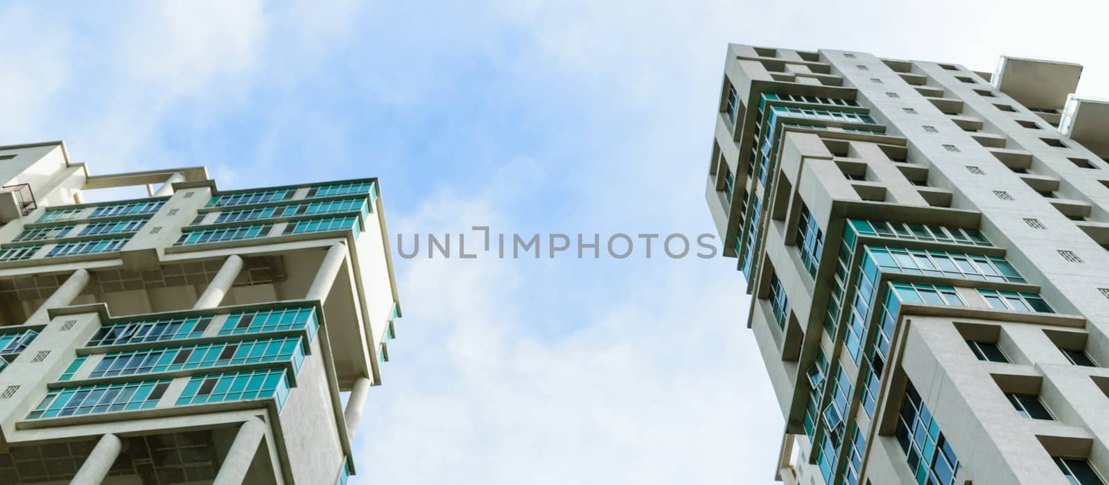 Low angle view of Modern skyscrapers Buildings in Kolkata City. Sunlight reflection, blue sky and white Fluffy clouds during sunset. Directly below view. Slanted, Tilt, diminishing perspective, Copy space room for text. by sudiptabhowmick