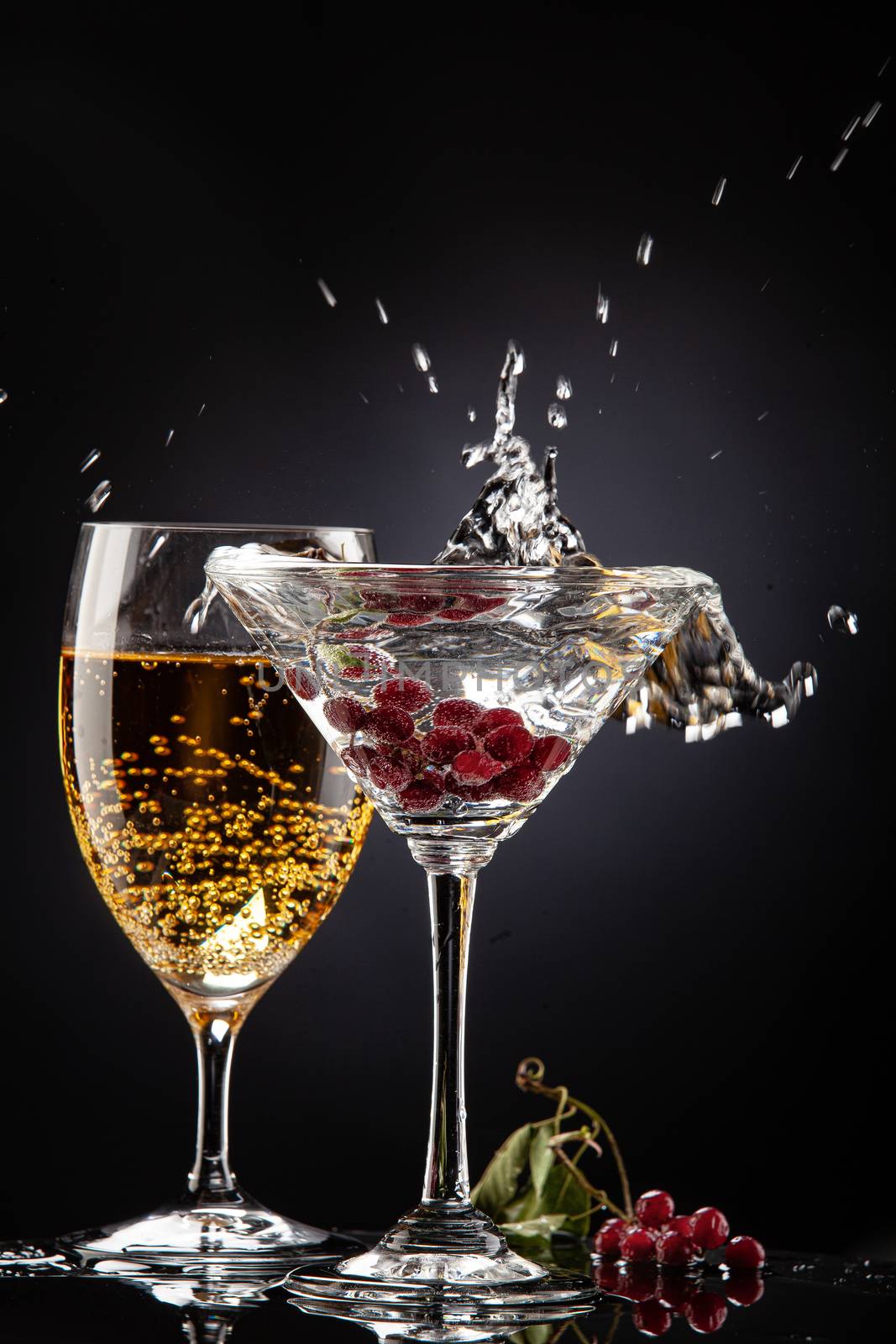 Bunch of red currant falling into the glass of water