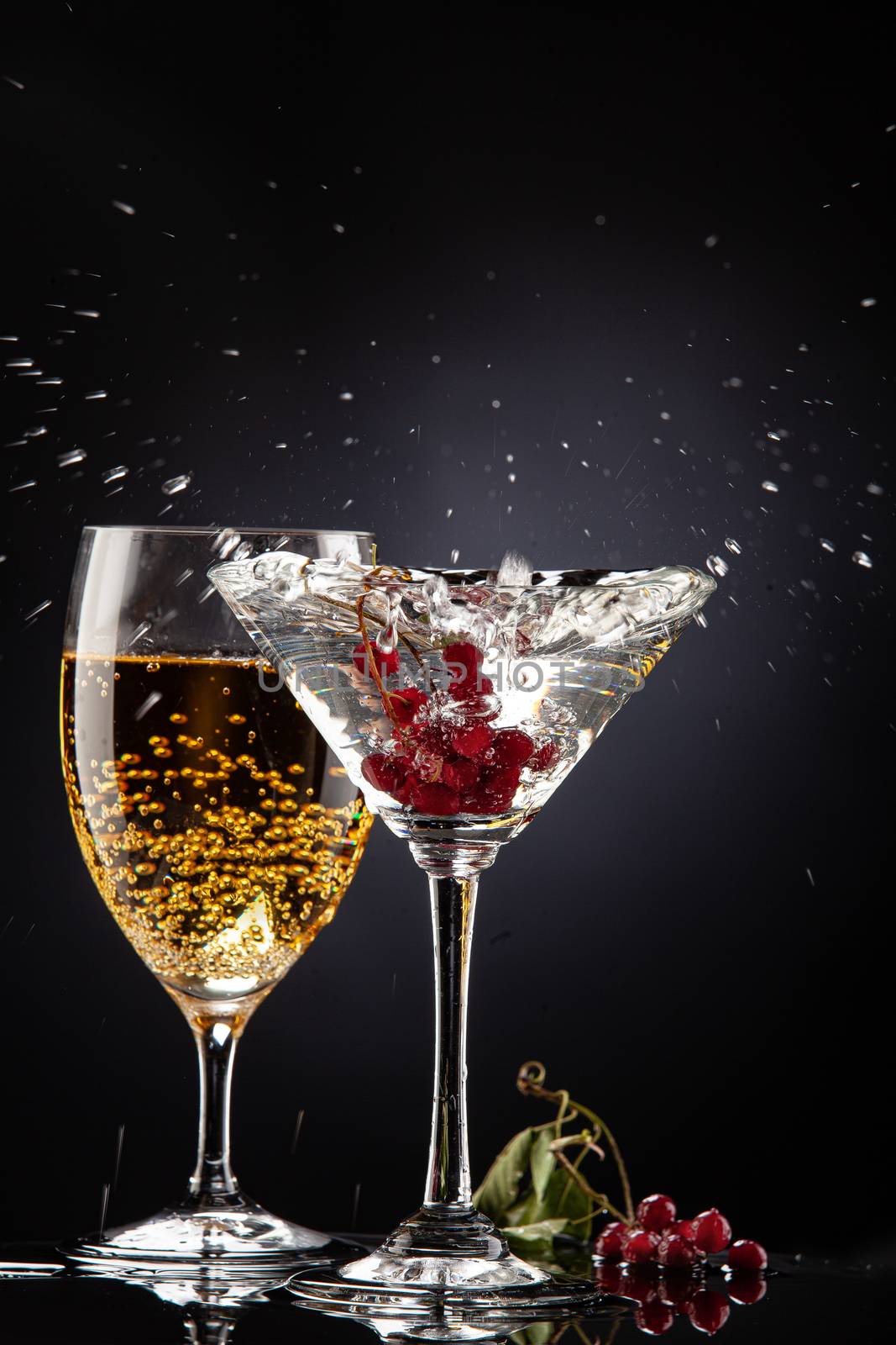 Bunch of red currant falling into the glass of water