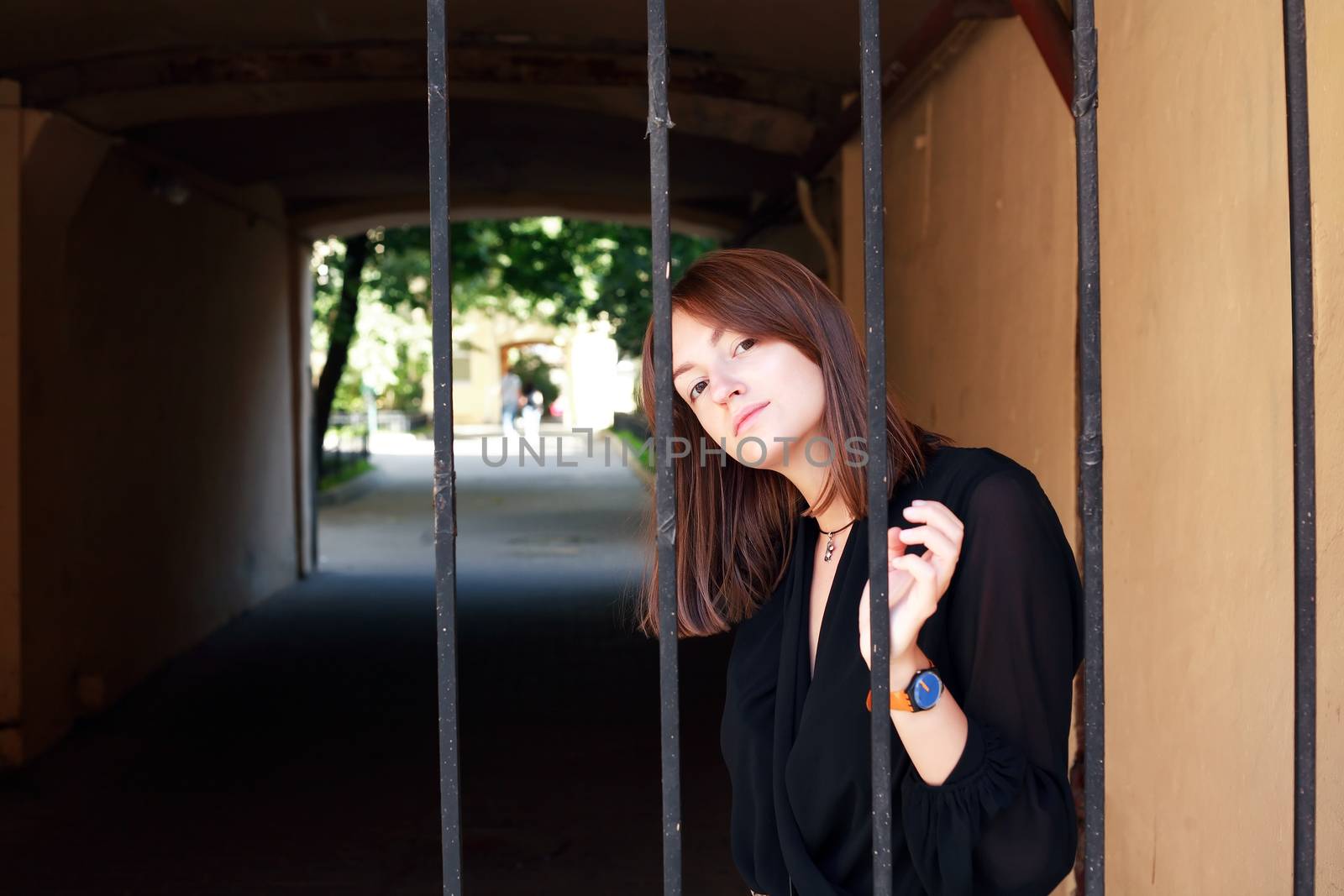 Beauty young woman in front of the old lattice gate in house arch