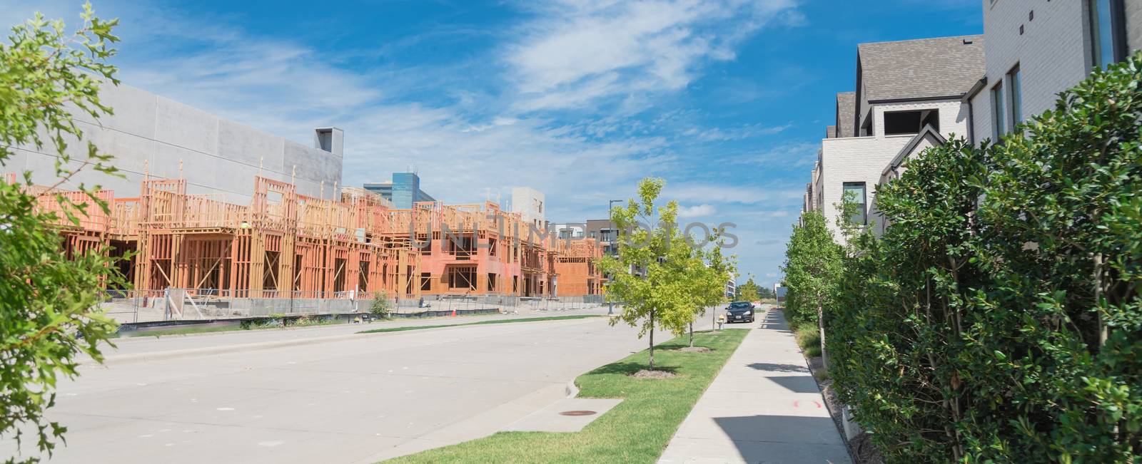 Panorama view brand new development community in North Dallas, Texas, USA with mixed of single family detached residential houses and upscale multistory apartment building under construction