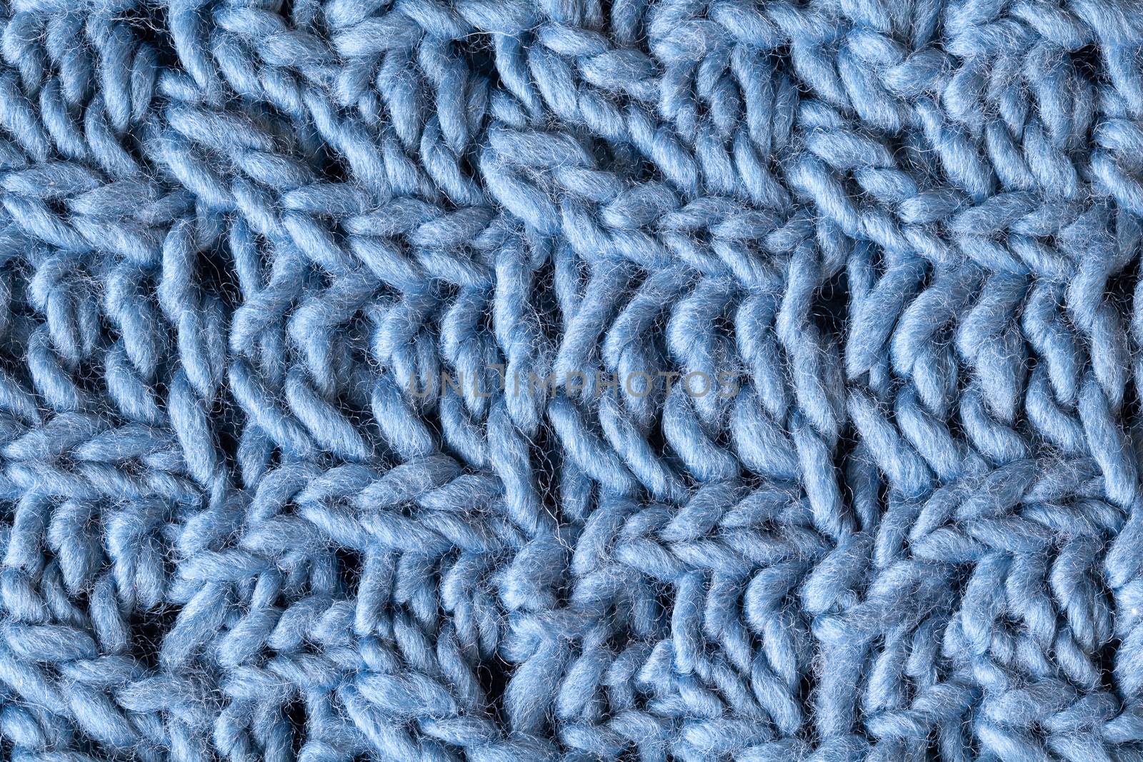 Knitted woolen textured surface, macro. Soft grey blue merino wool pattern backdrop, closeup. Autumn and winter flat lay. Scandinavian minimal style.