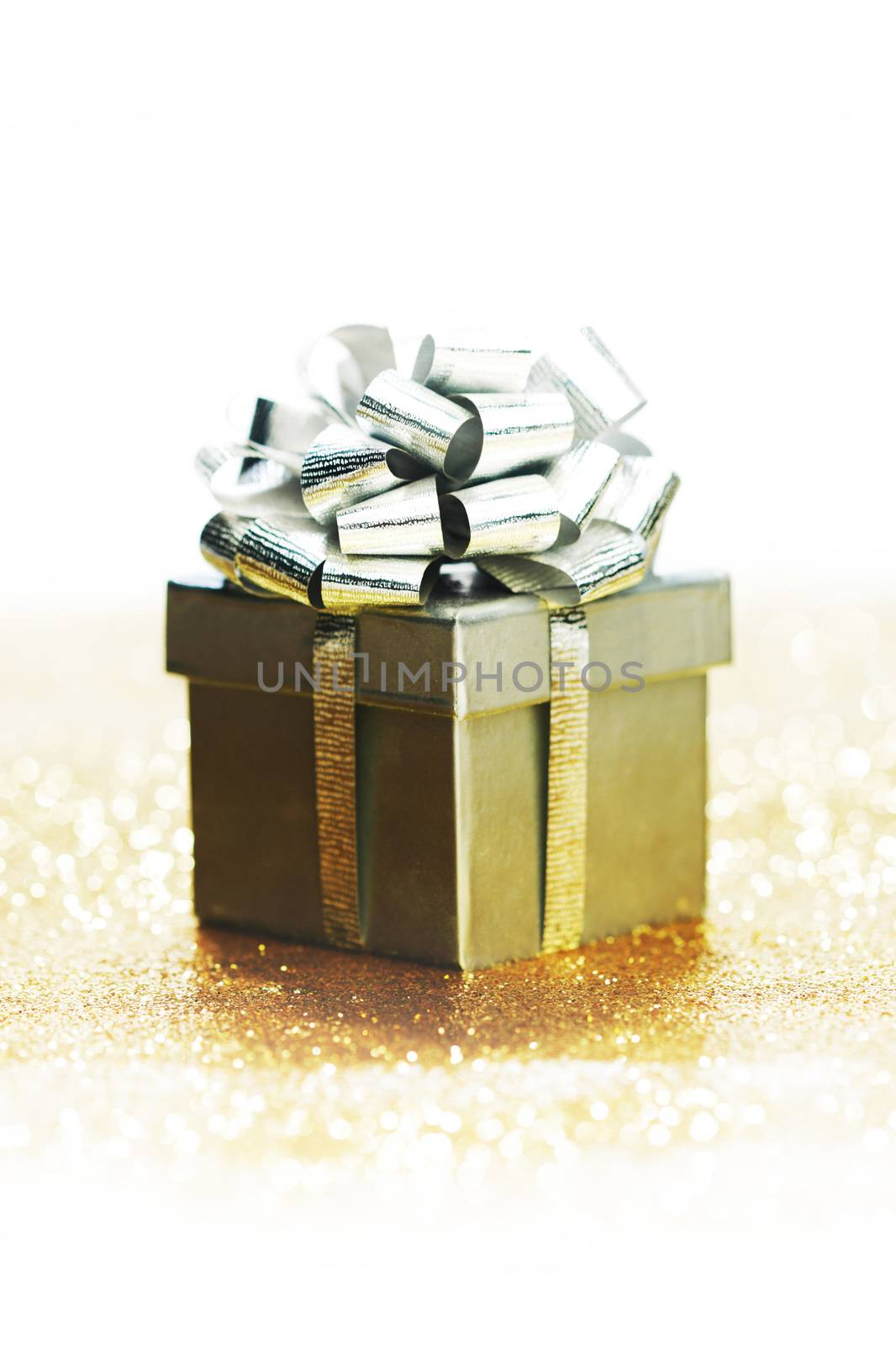 Silver decorated gift on golden glitters background