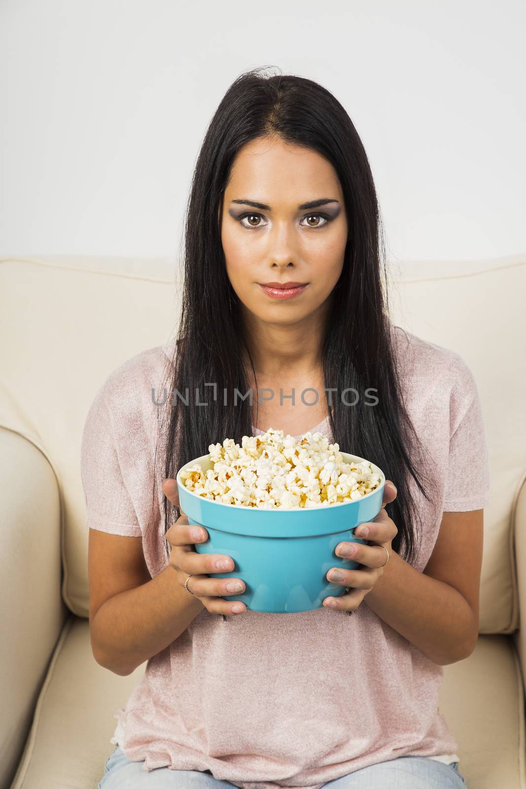 young woman holding a blue bowl filled with popcorn