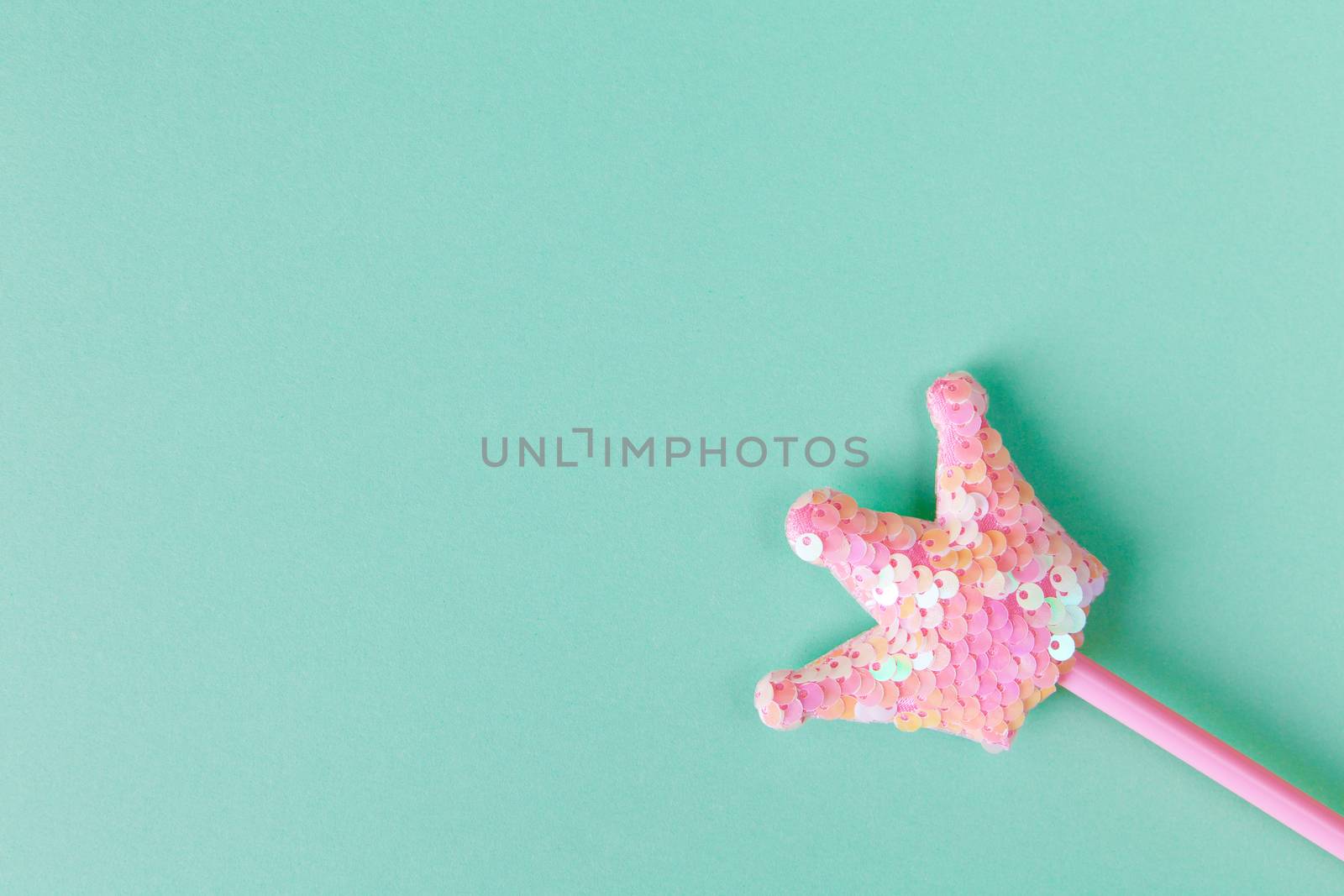 Party accessory, fairy wand. Pastel turquoise background, copy space. Holiday festive flat lay. Minimal style. Horizontal. Top view, close-up