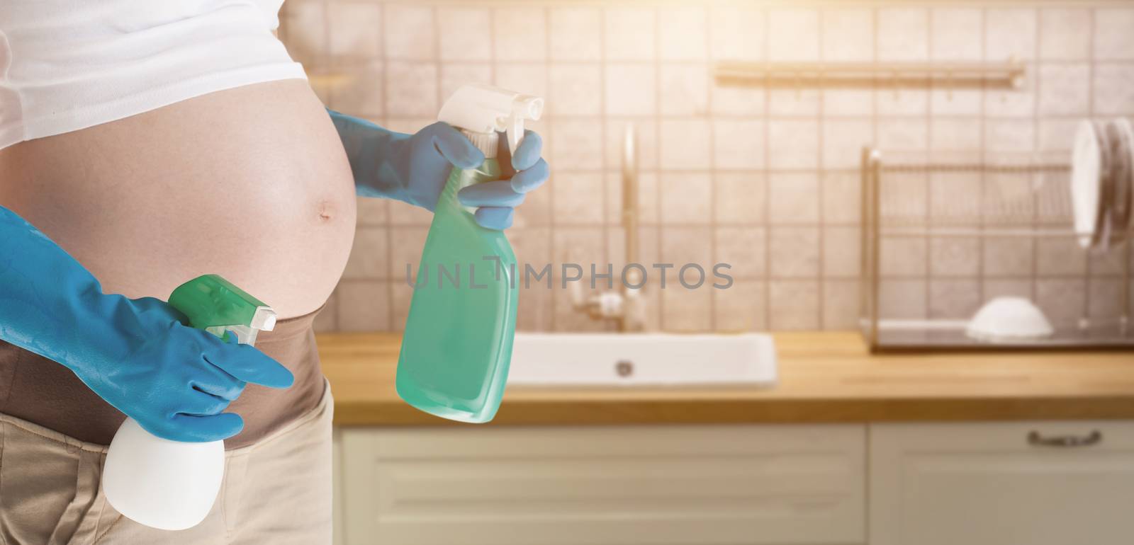 A pregnant woman wearing blue gloves cleaning the toilet.