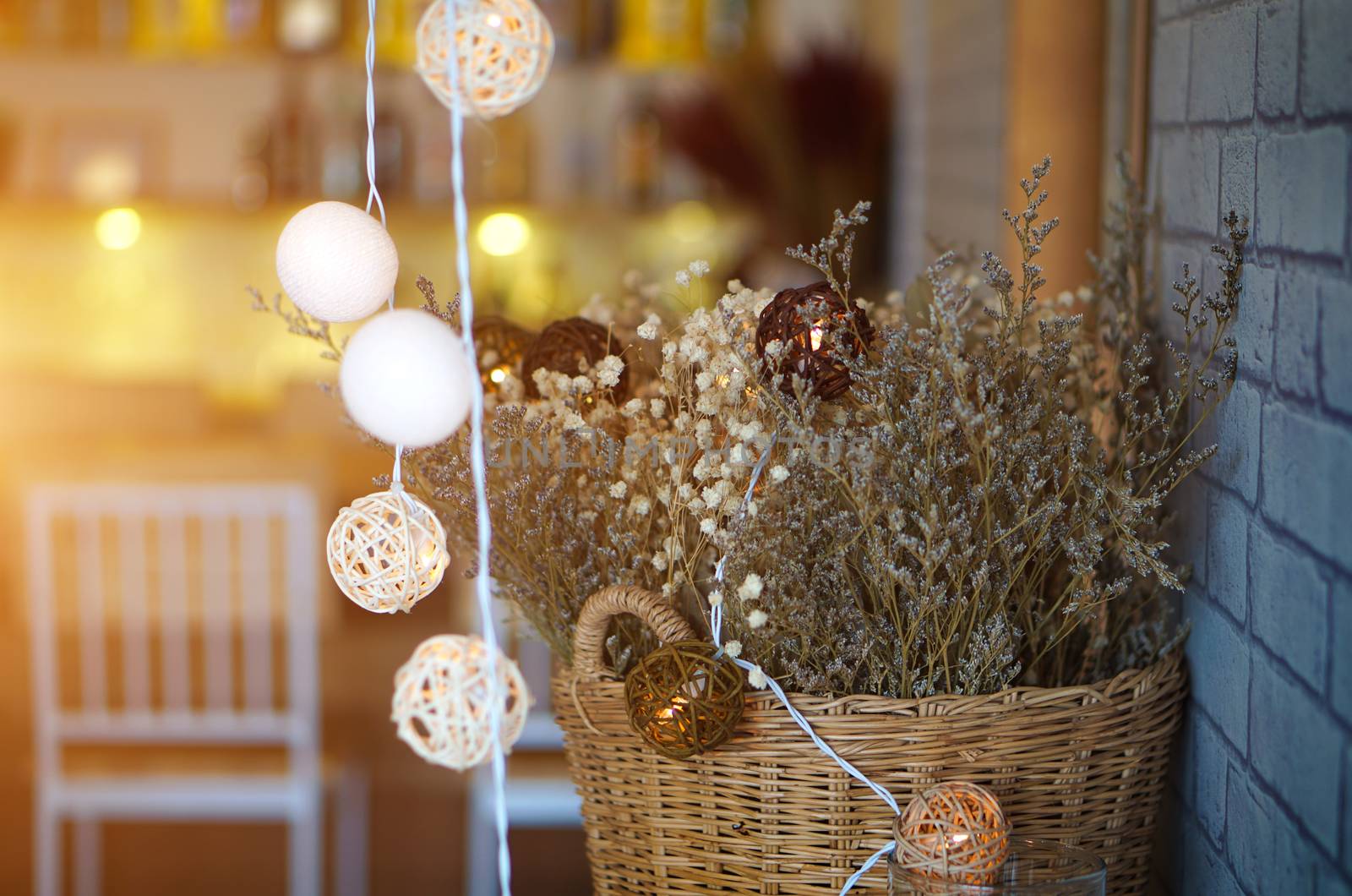 Dried flowers in a vase made of Basket of wood and bokeh light. The interior of the restaurant.
