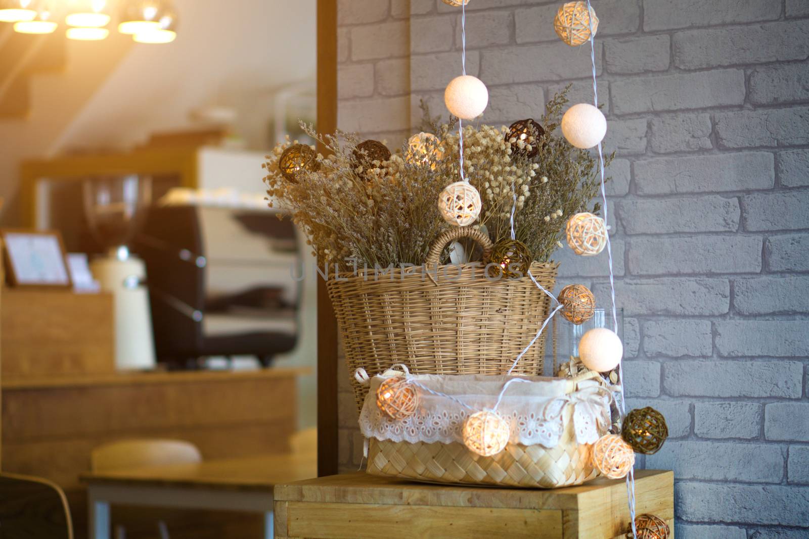 Dried flowers in a vase made of Basket of wood and bokeh light. The interior of the restaurant.