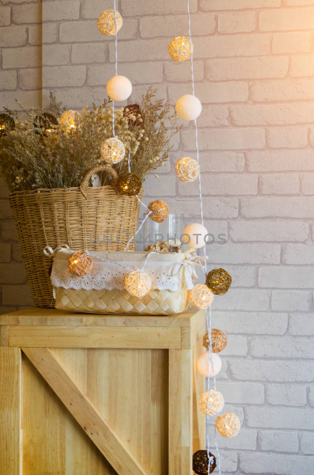 Dried flowers in a vase made of Basket of wood and bokeh light. The interior of the restaurant.