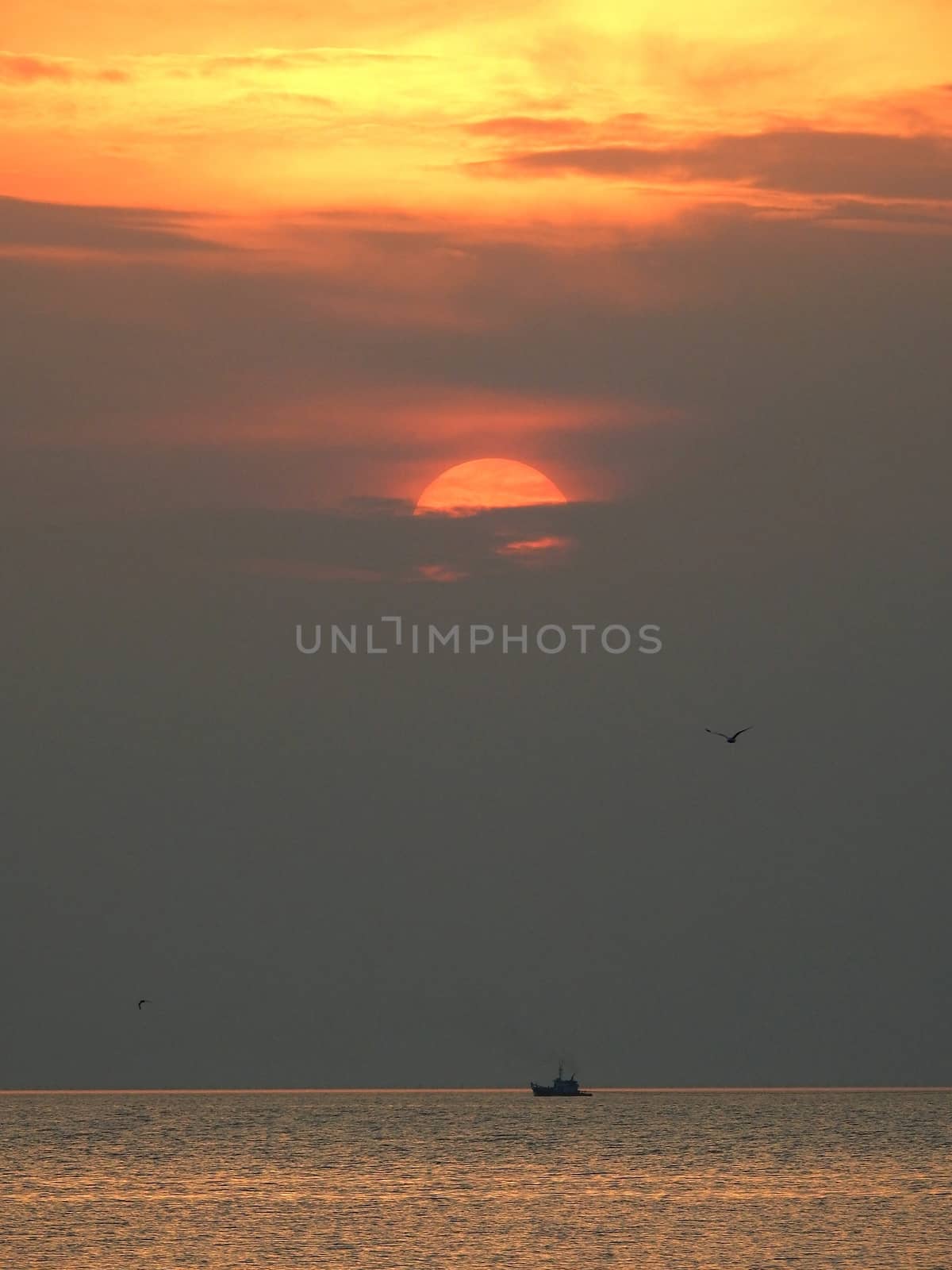 Sunset and  lonely boat at thailand sea by pkproject