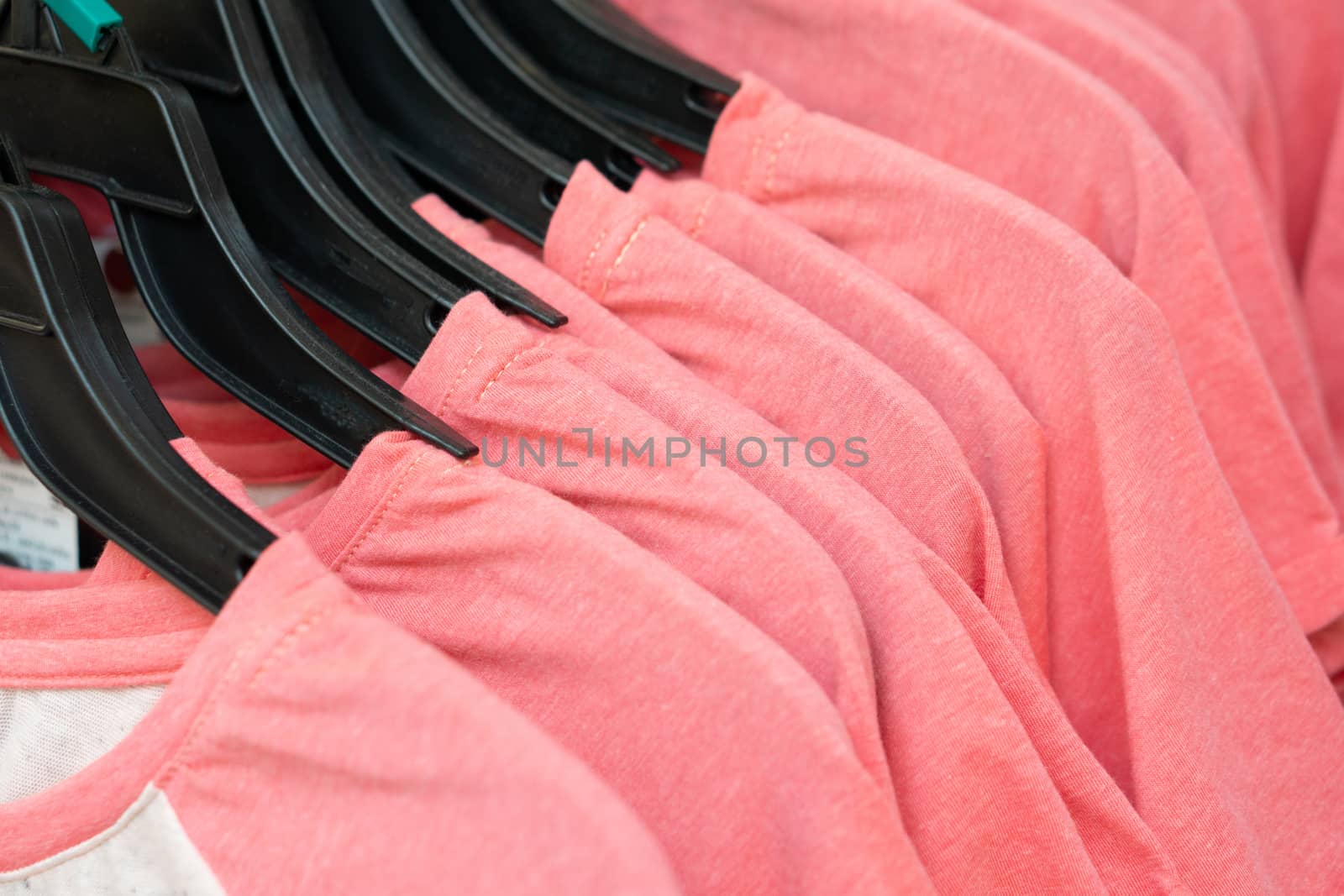 Row of pink t-shirts in a store.