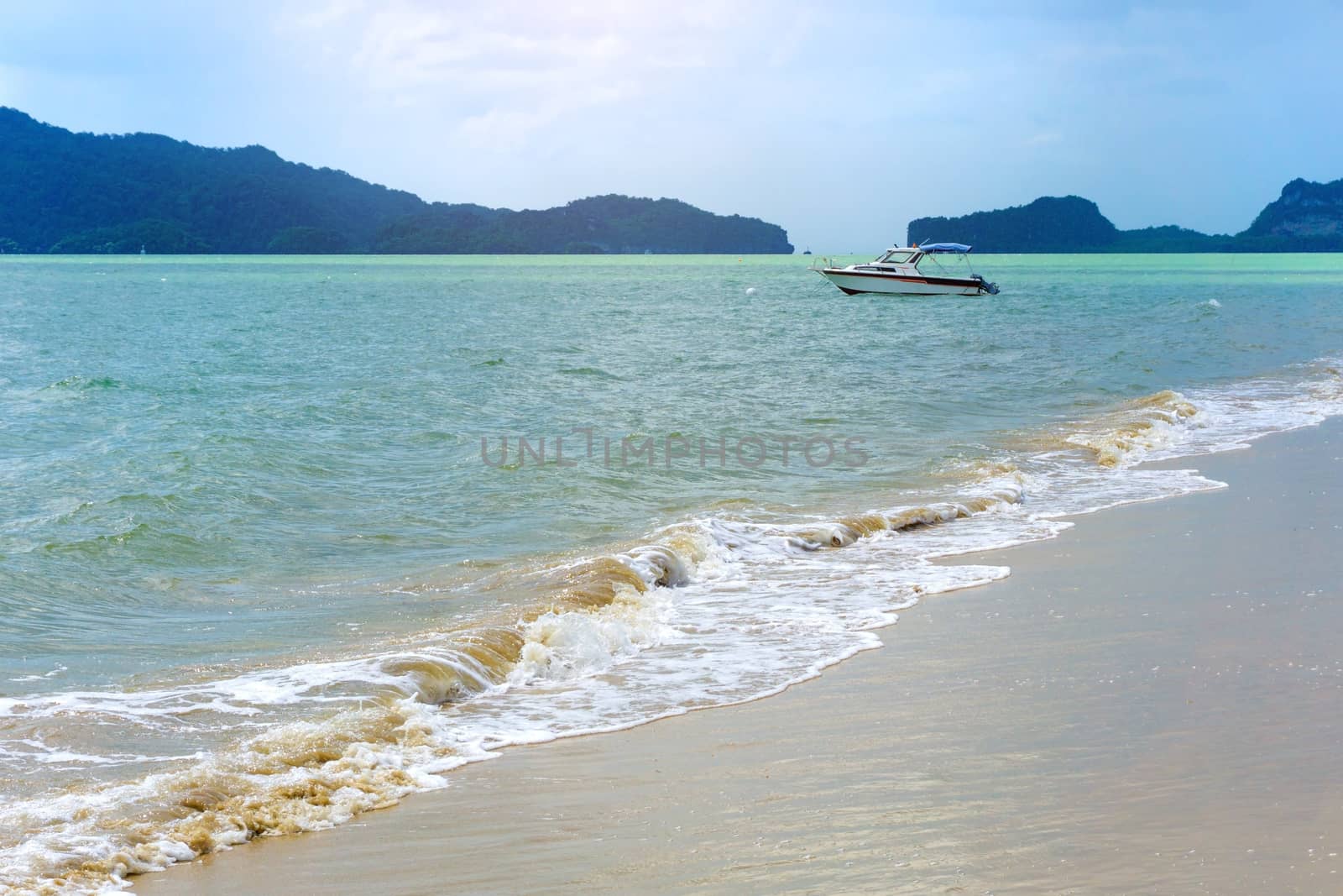 Boat on blue water and white sand beach in thailand sea, Satun Province.