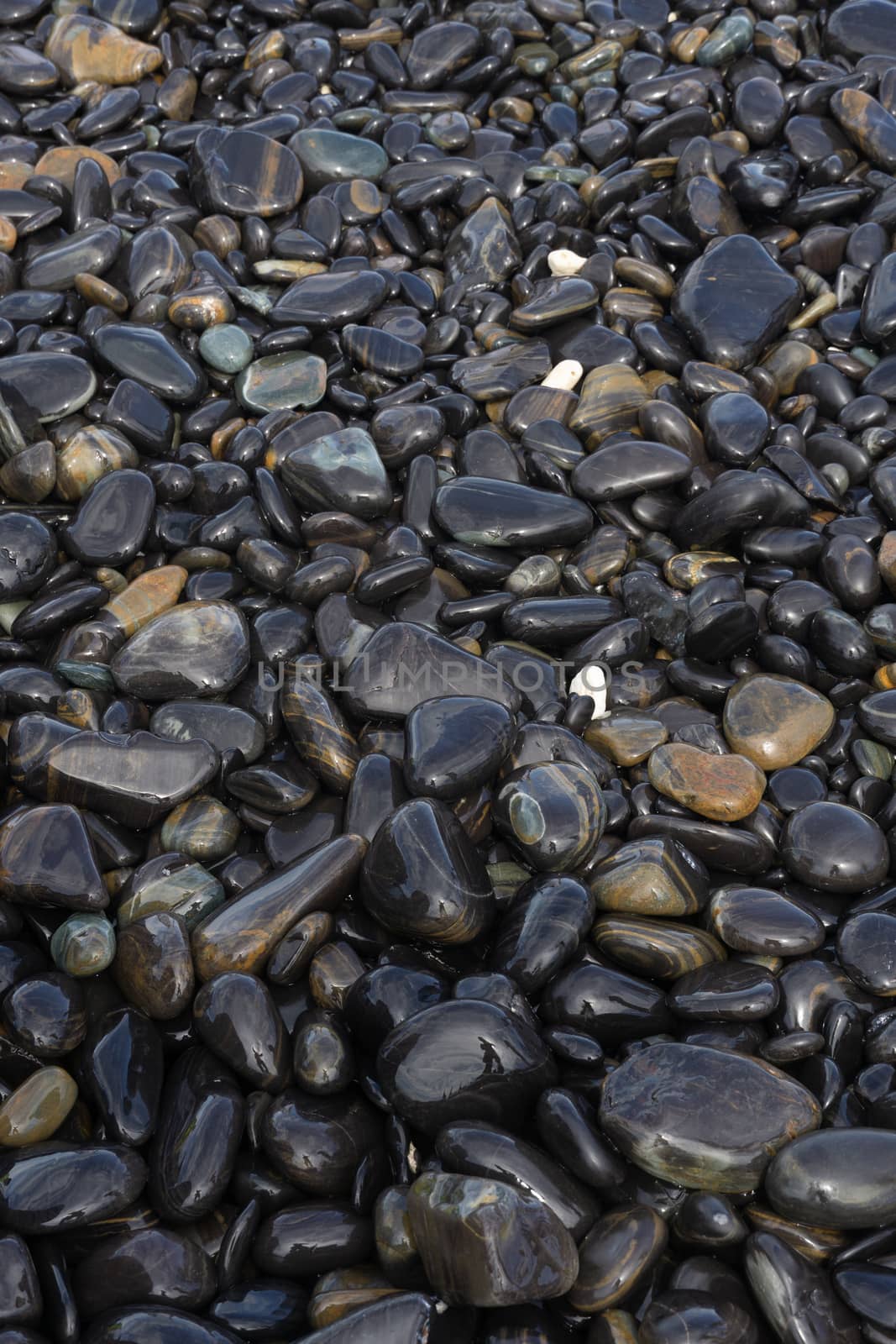 Wet Black pebble stones island in Koh hin ngam, Tarutao National Park, Satun, Thailand.