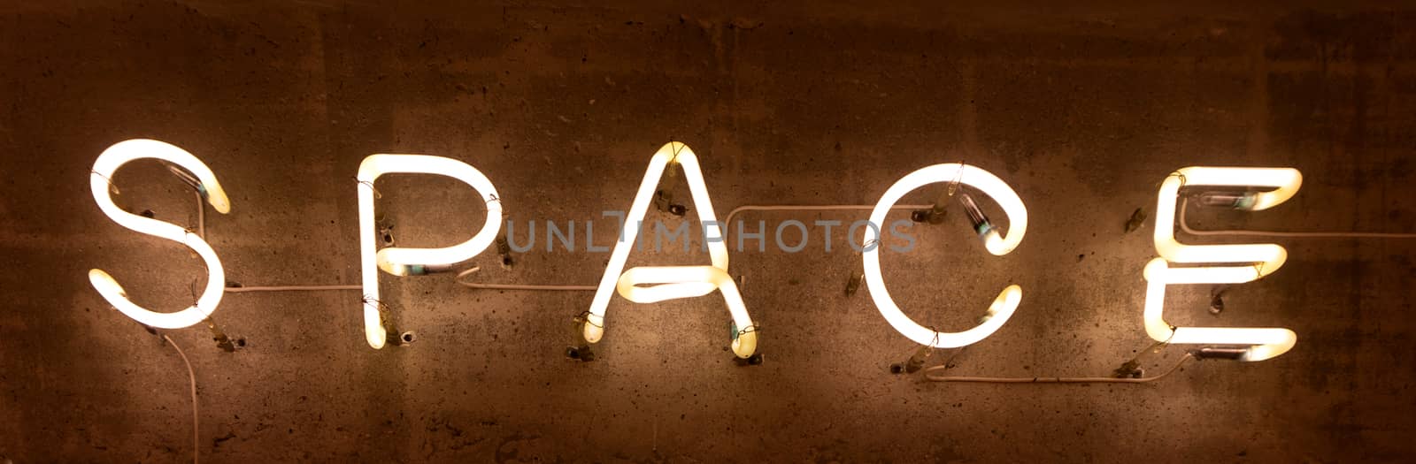 Neon inscription "Space" on a concrete wall texture.