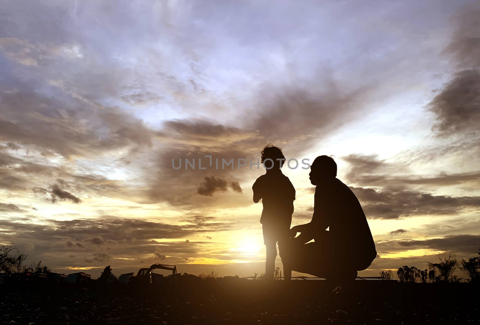The silhouette of the father and son who enjoyed the sunset for  by pkproject
