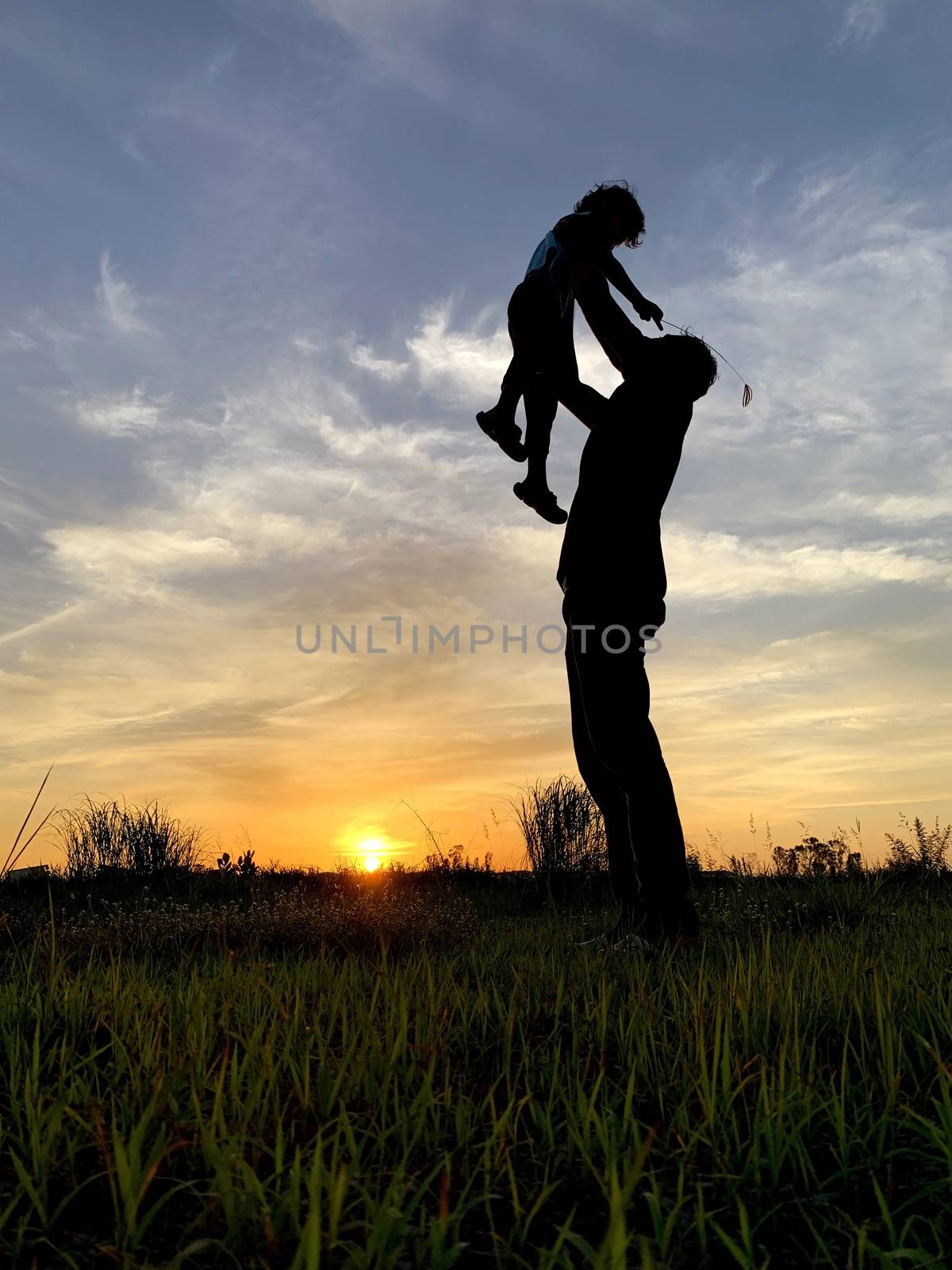 Silhouette Father Carrying Son Against Sky During Sunset by pkproject