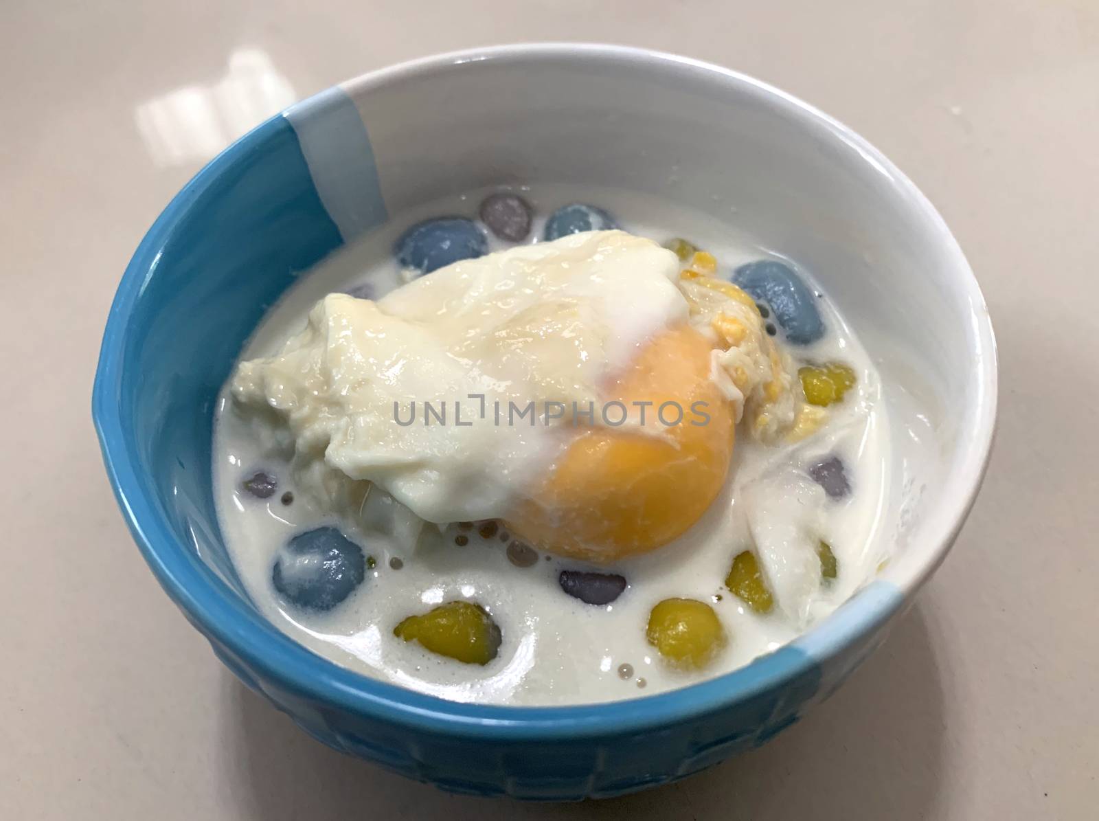 Sticky rice pearls in coconut milk with poached egg in light syrup