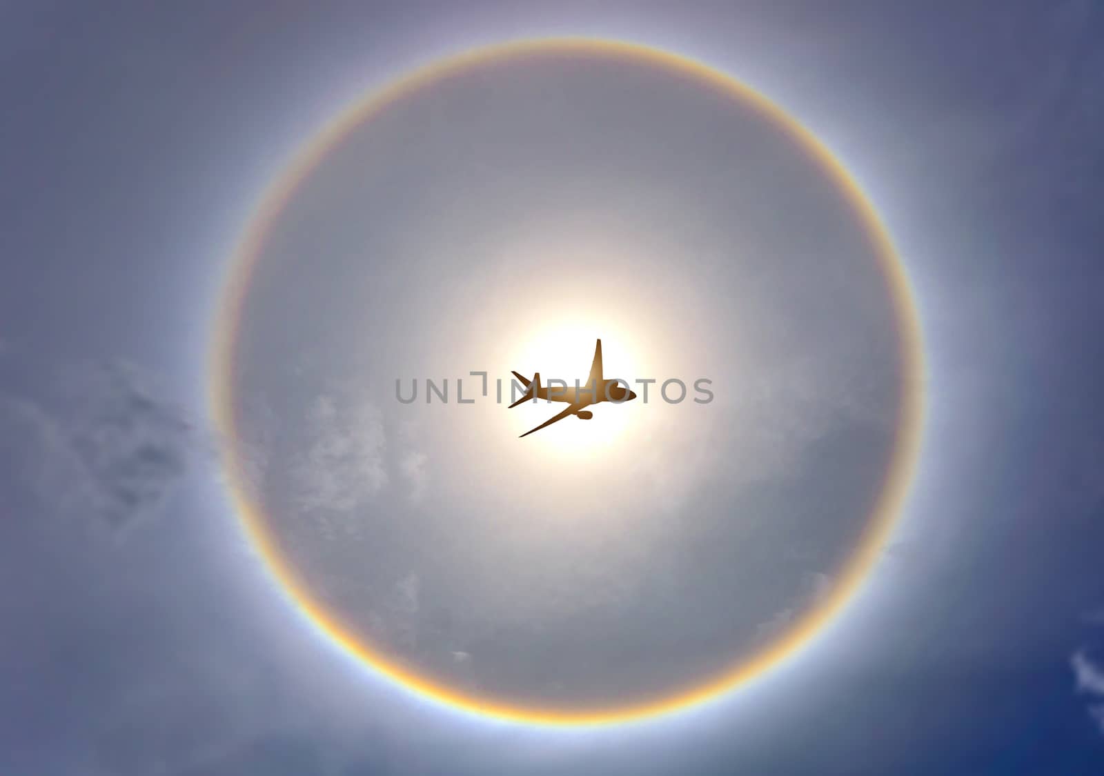 The plane is flying and has a rainbow background that exceeds the sun halo.