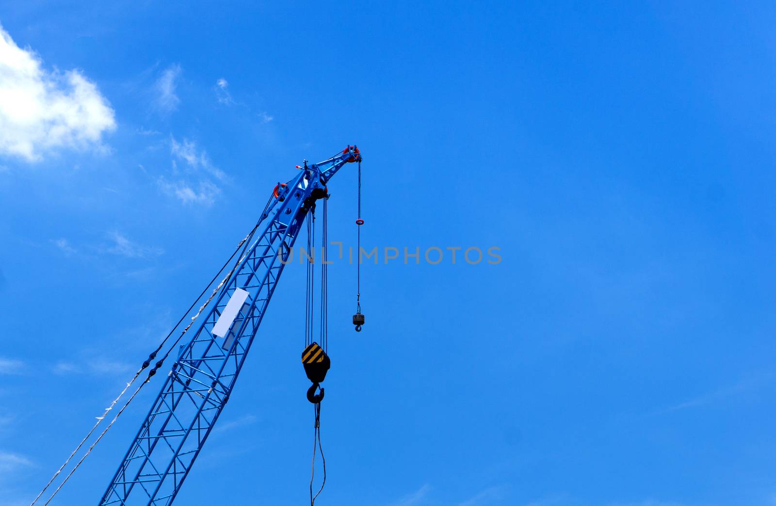 Blue Construction crane on blue sky background in progress at Construction Site.