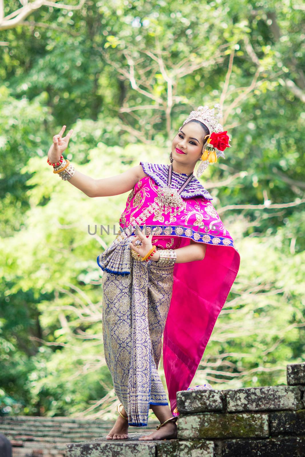 Asian woman wearing typical, traditional Thai Dress. It is literally means "Thai outfit", National costume.
