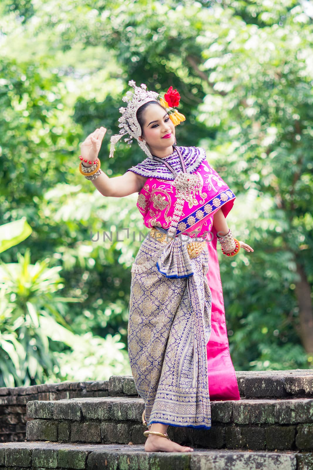 Asian woman wearing typical, traditional Thai Dress. It is literally means "Thai outfit", National costume.
