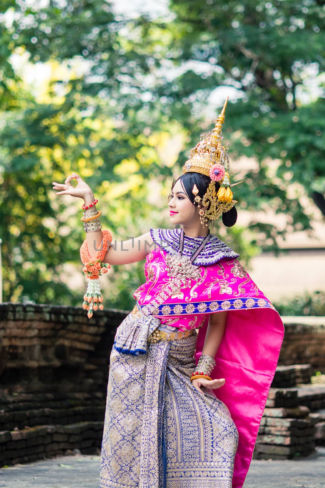 Asian woman wearing typical, traditional Thai Dress. It is literally means "Thai outfit", National costume.
