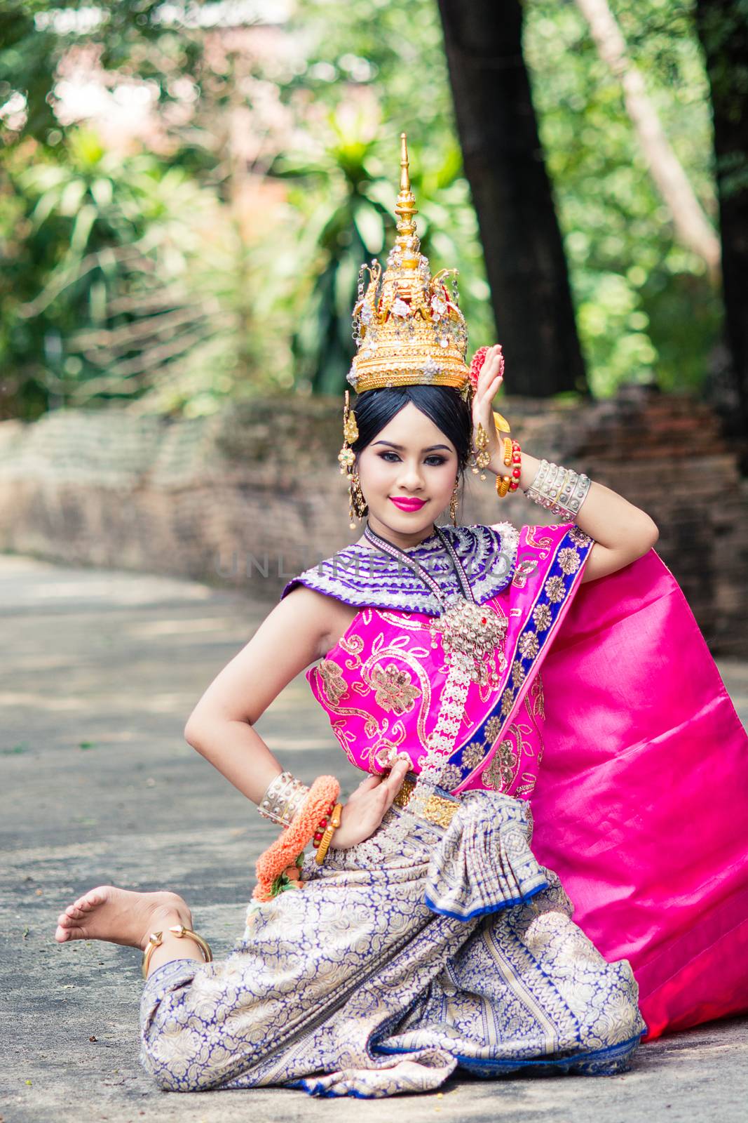 Asian woman wearing typical, traditional Thai Dress. It is literally means "Thai outfit", National costume.
