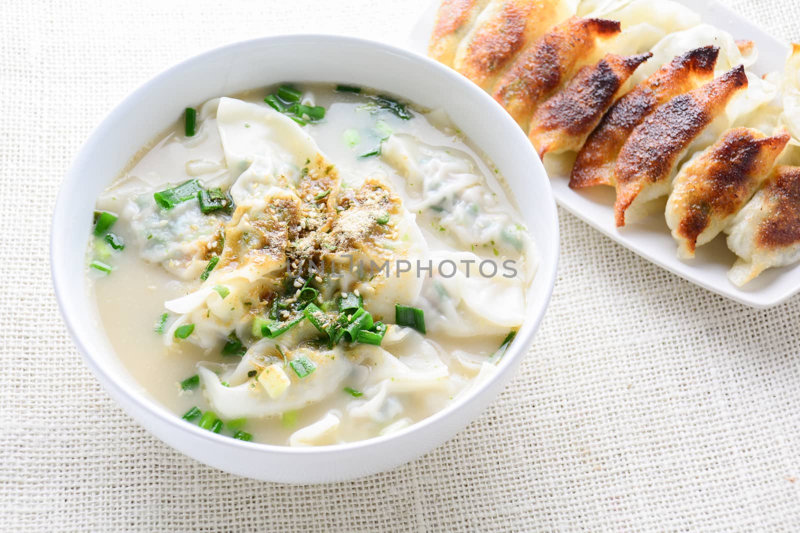 Wonton soup with spring onion served in a white bowl, selective focus
