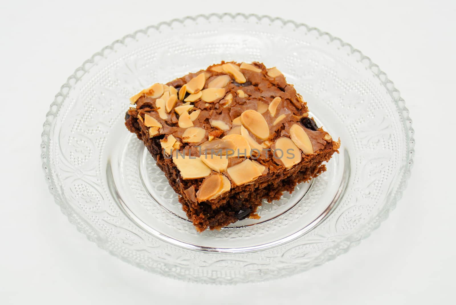 Chocolate brownie with almond topping on glass plated by yuiyuize