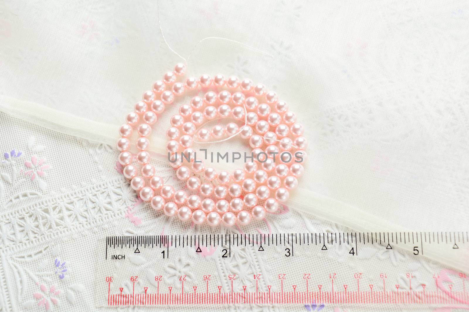 pearl necklace on white fabric background, Close up shot of glas by yuiyuize