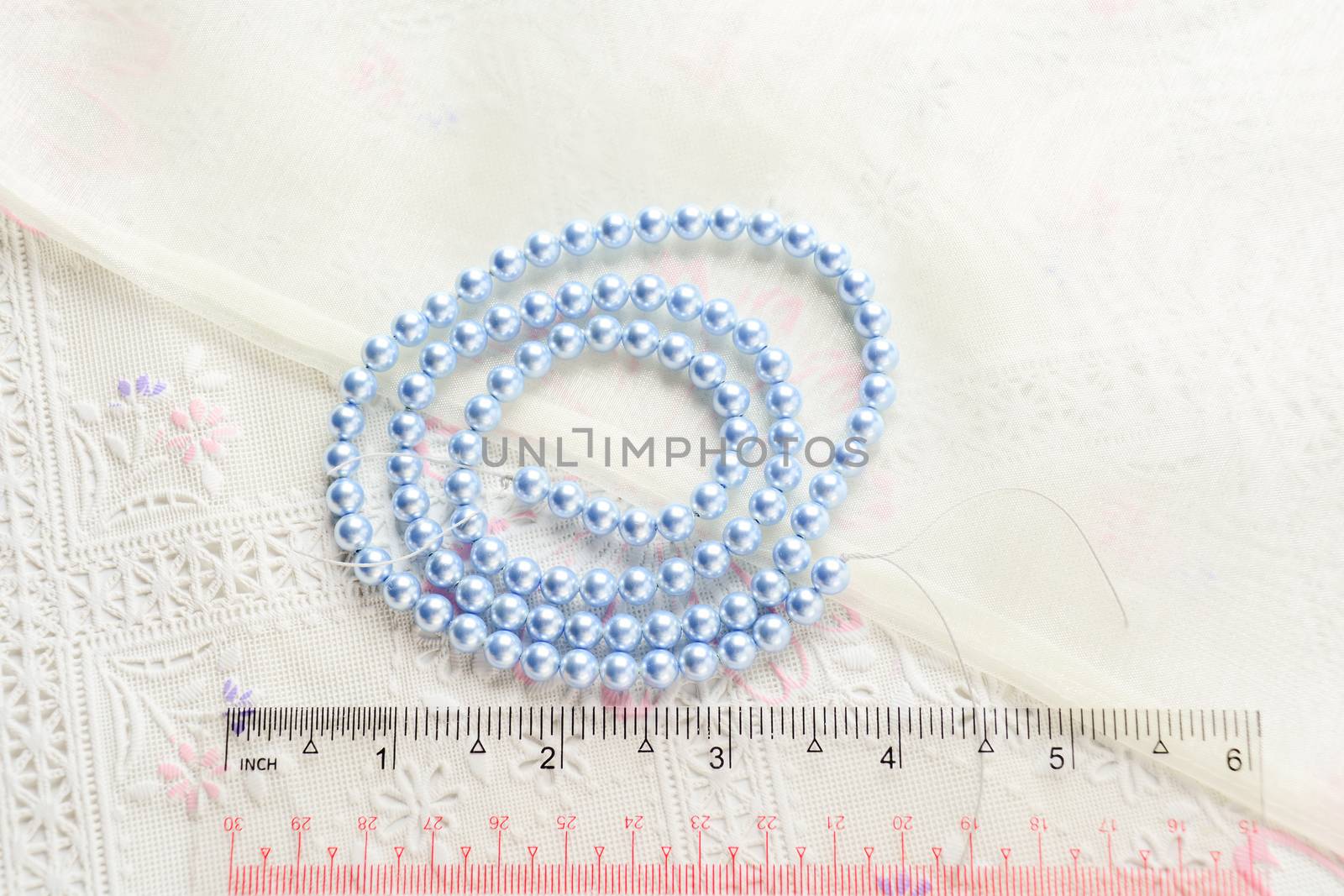 pearl necklace on white fabric background, Close up shot of glas by yuiyuize